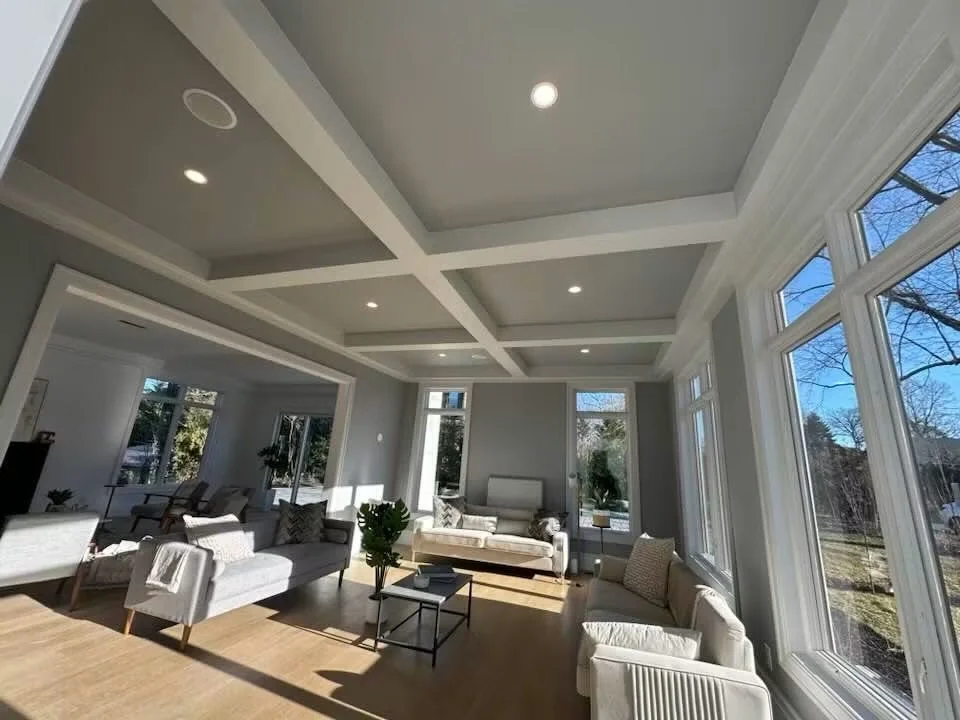 Recessed lights in a coffered ceiling above a furnished living room