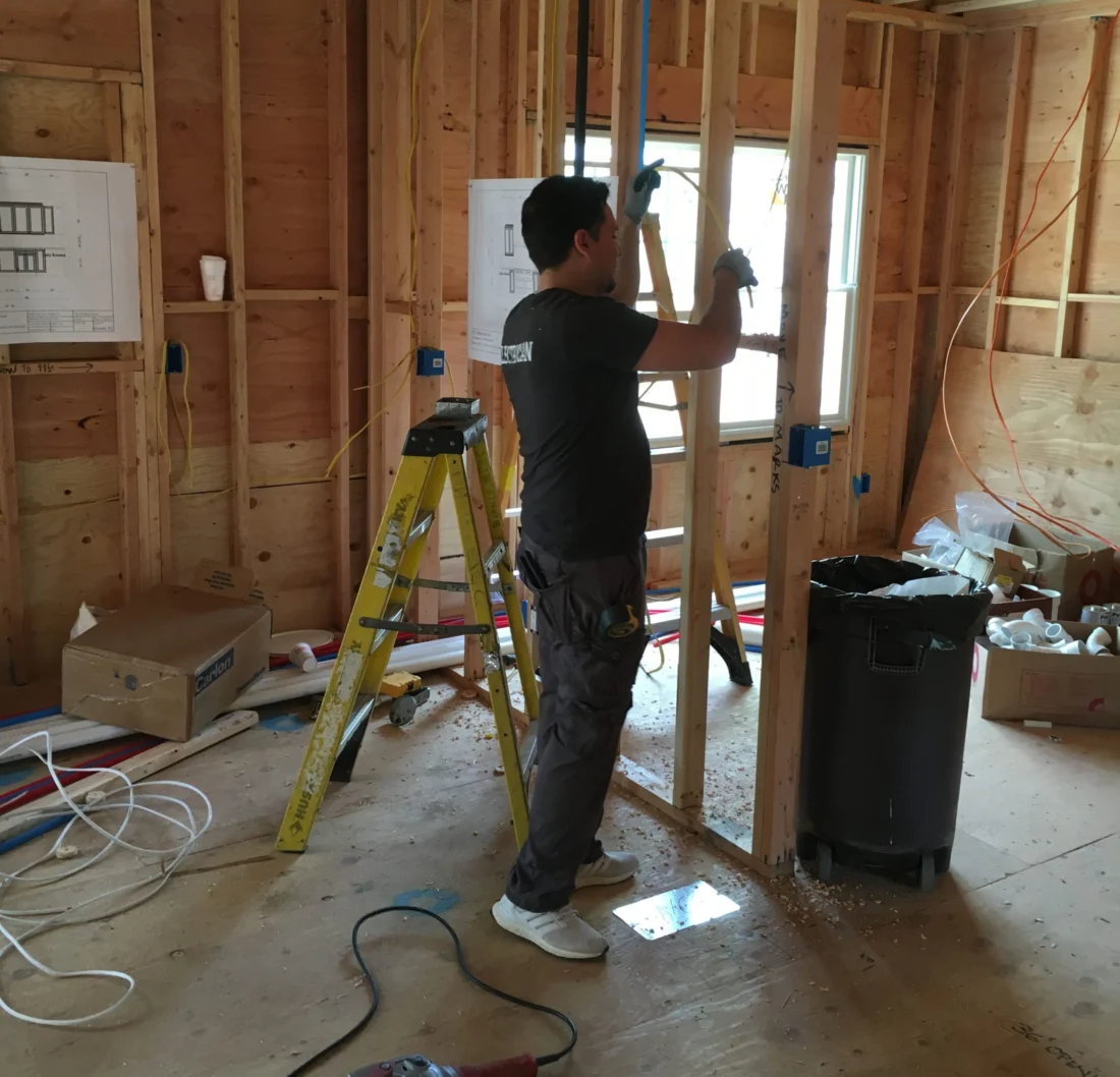 Electrician installing wiring in a home under renovation